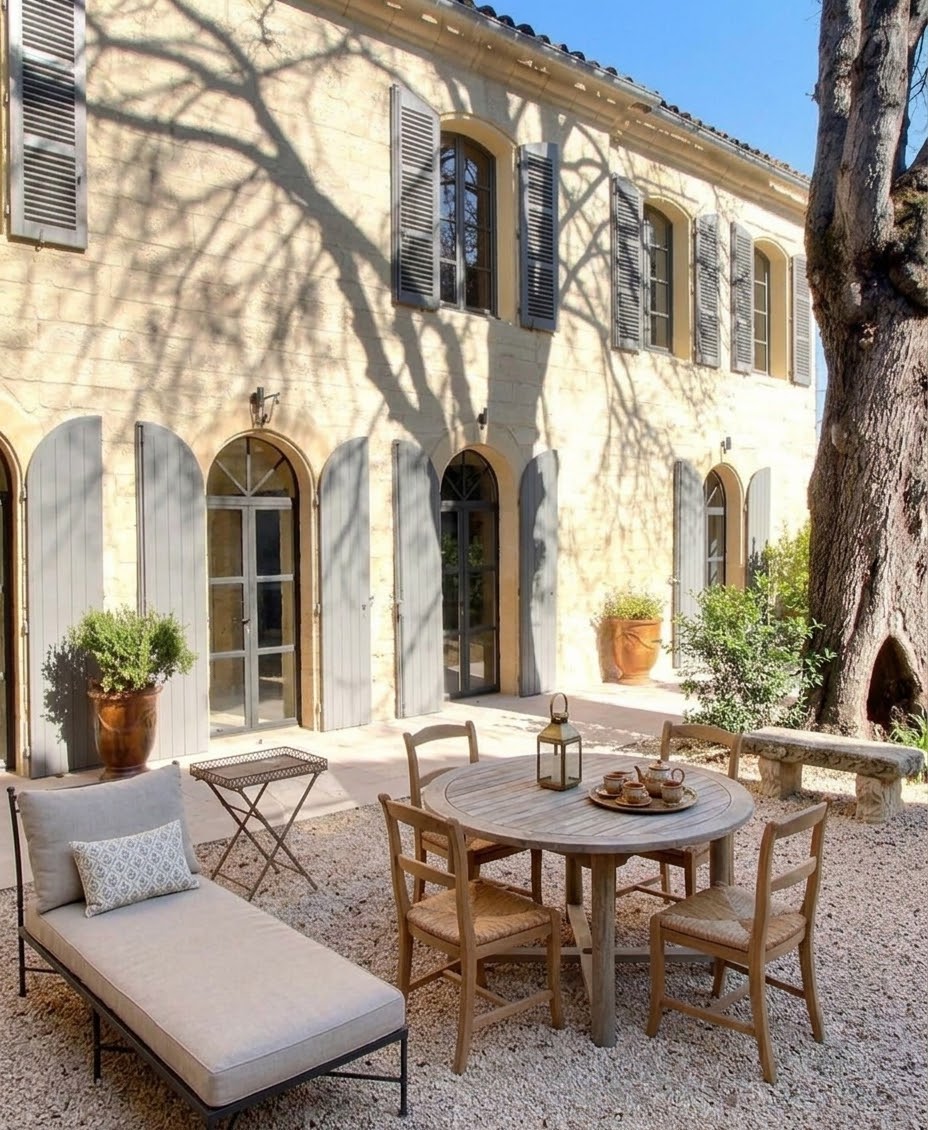 Stone Provençal patio with grey shutters and arched glass doors